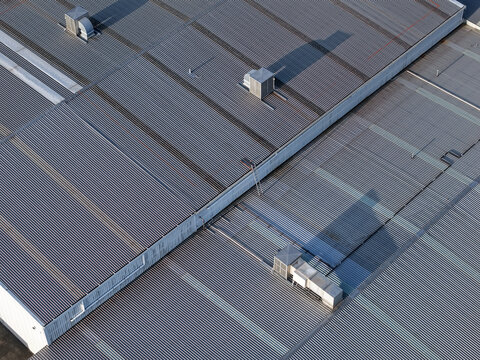 Melbourne, Australia - 22 September 2026: Aerial view of industrial factory rooftops with metal corrugated sheets, ventilation units, and shadows cast by the afternoon sun in Kilsyth.