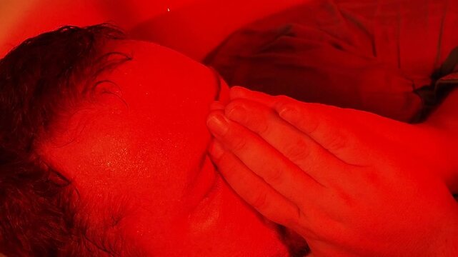 A man suffers while lying in the bathtub late at night