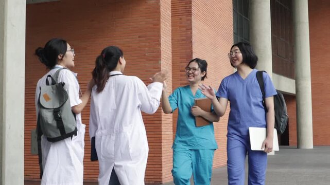 Group medical students greet each  warmly university campus exchanging friendly high fives smiles before heading class in the building classmates medical program get know one friendly atmosphere.