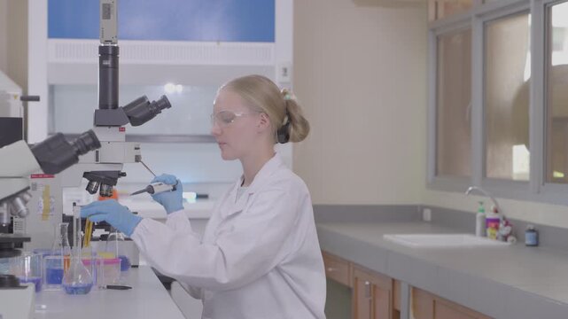 Science, microscope and study with of a woman in a laboratory for research and innovation. Medical, pharmaceutical sample and a young scientist in a lab for development, discovery or breakthrough