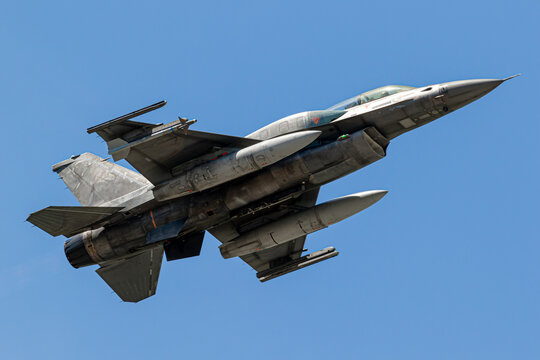 Armed military fighter jet in flight carrying missiles, illustrating modern air power, military aviation and defense technology.
