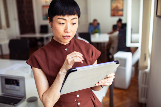 Focused woman using digital tablet in modern office