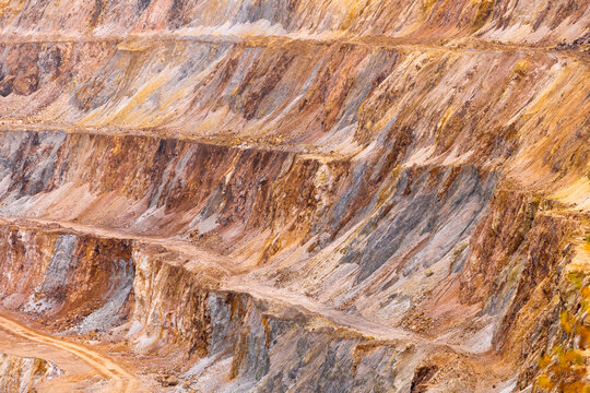 Geamana, Romania - 21 September 2026: Aerial view of the Geamana copper mine showing terraced slopes, exposed mineral layers, and industrial excavation patterns.