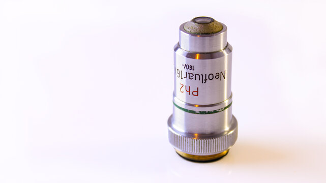 Close-up of a Neofluar phase-contrast microscope objective marked 16x, featuring a silver metal body, green ring and knurled mounting ring.