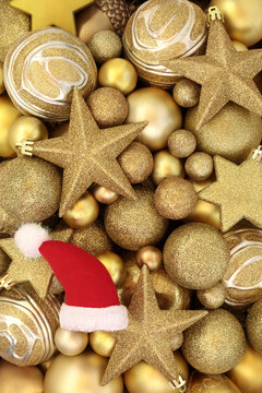 Christmas santa hat gold sparkling star and ball bauble decorations. Festive Xmas background with decorative holiday symbols. 