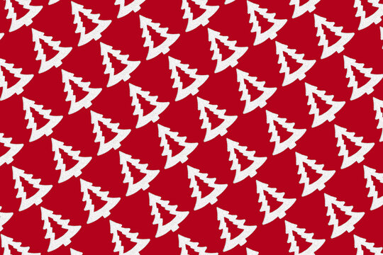 Diagonal Christmas tree seamless repeat pattern design on red background. Magical Xmas decorations for wrapping paper or greeting card.
