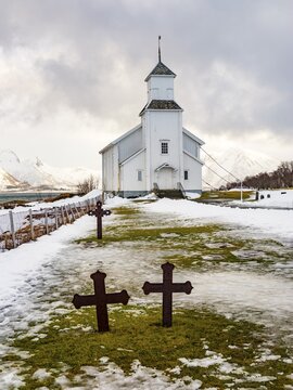 Gims&oslash;y church with cemetery, snow-covered mountains in the background, winter, Gims&oslash;ya, Lofoten, Norway