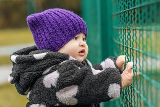 Toddler missing parents at daycare fence outdoors