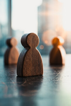 Wooden human figures standing on a dark surface
