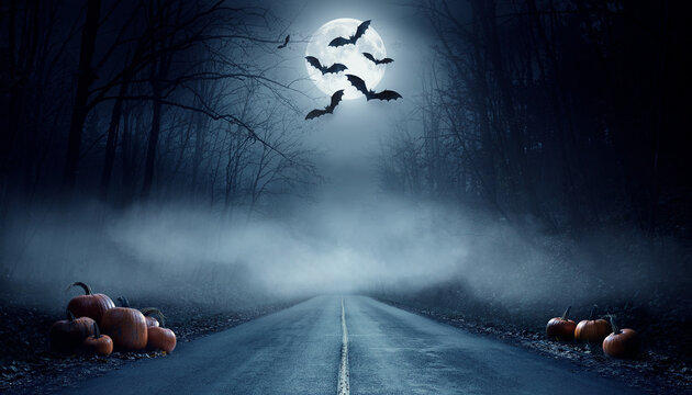 Spooky halloween night scene with a foggy road and bats flying under a full moon.