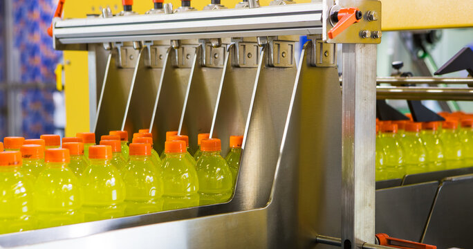 Yellow sports drink bottles moving along a production line