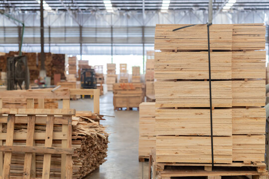 Stacks of wooden boards and wooden pallets in the warehouse