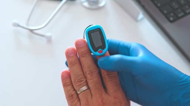 Medical professional using a fingertip pulse oximeter to check a patient's oxygen level