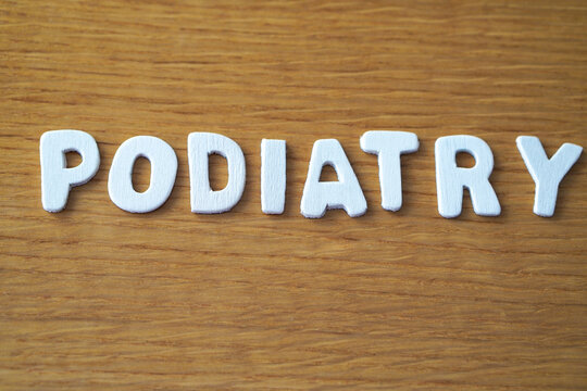 Podiatry. A word formed with wooden letters, accompanied by a medical stethoscope.