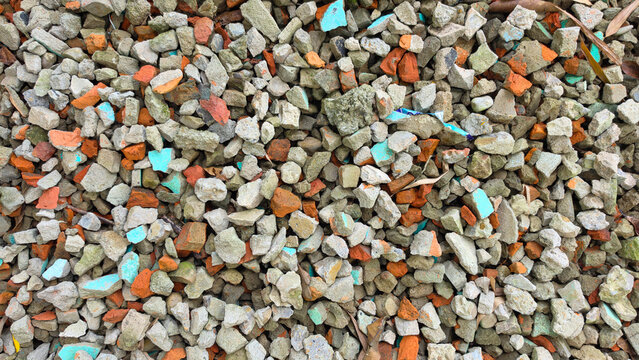 Top view of crushed concrete and brick rubble with colorful painted fragments for construction texture