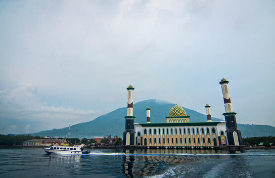 Scenic view of Al Munawwar Floating Mosque on the coast of Ternate City, North Maluku, featuring green domes and tall minarets by the sea.