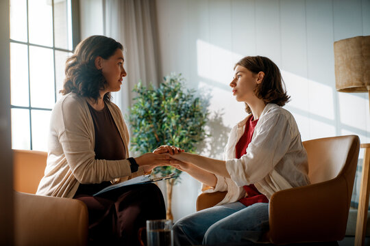 Female Therapist Supporting Young Woman During Counseling Session