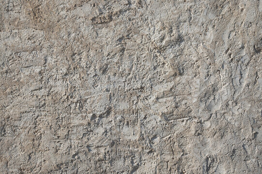 Gray yellow background, photo of the texture of an old wall with various lines, embossing, and brushstrokes