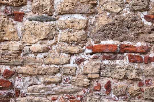The photo shows a wall made of old brick and stone