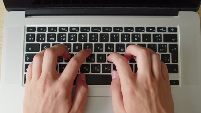 Man typing on a laptop. Top down close up shot of a person actively typing on the keyboard of a modern laptop. Overhead view of typing on a laptop.