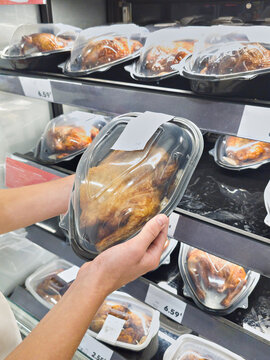 Shopper Choosing Packaged Roasted Chicken in Supermarket