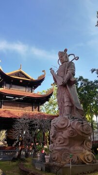 Tracking Shot of Guardian Deity Stone Statue with Traditional Musical Instrument at Ho Quoc Pagoda on Phu Quoc Island Vietnam