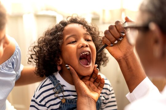 Child having a throat examination by a healthcare professional.