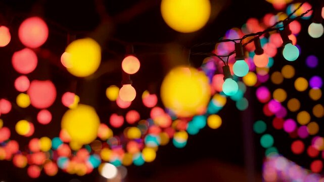 Colorful festive string lights bokeh flickering on dark background, abstract celebration festival loop
