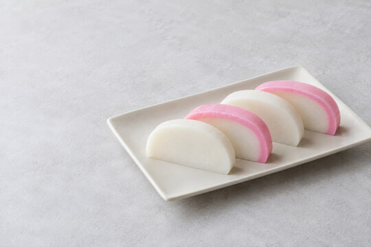 Pink and white Japanese kamaboko slices with copy space