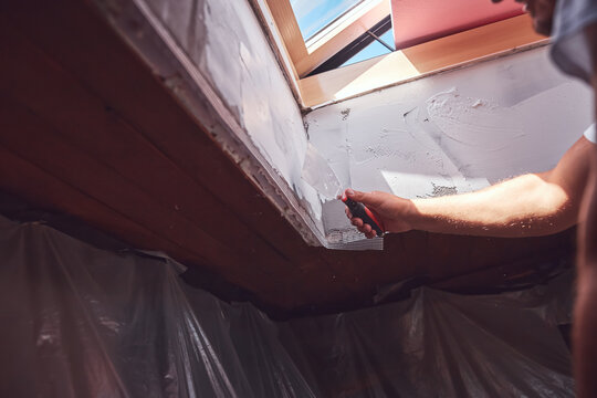 House painter putting skim coat and working on a home renovation.