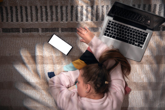 Woman using smartphone and laptop at home &ndash; remote work, online communication and digital lifestyle.