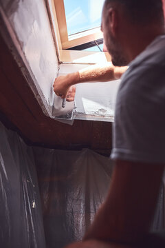 House painter putting skim coat and working on a home renovation.