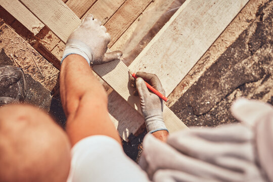 Construction worker working outdoors on a roof renovating.