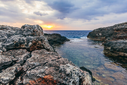 Sunset seascape over rocky cove in Cala d'Or, Mallorca, Spain.