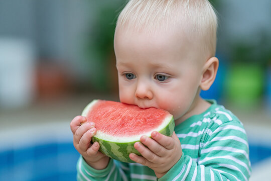 Little boy eating a slice of fresh watermelon with toddler eating