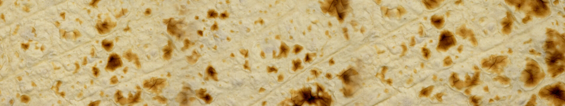 Traditional flatbread baking on a hot surface in an outdoor kitchen setting during the daytime