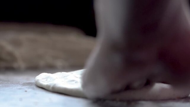 Close-up of preparing flatbread dough by hand.