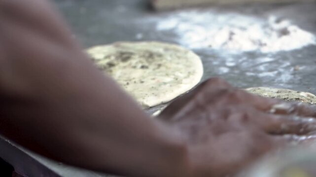 Close-up of preparing flatbread dough by hand.