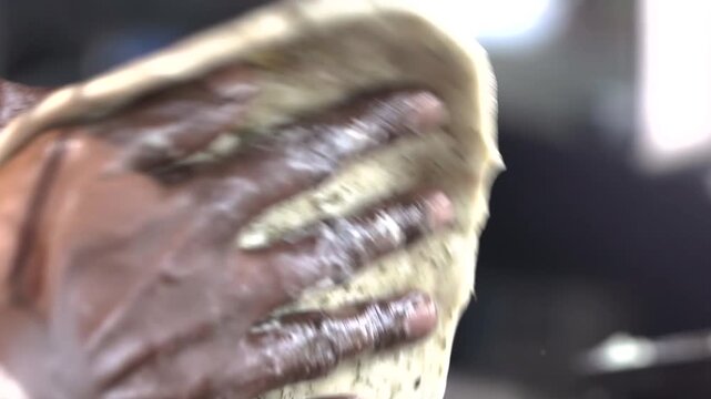 Close-up of preparing flatbread dough by hand.