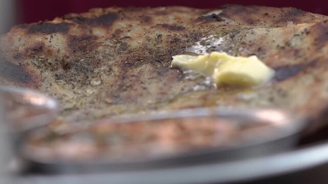 Close-up of butter melting on freshly cooked naan.