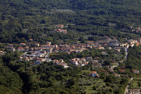 Panoramic aerial view of the rural village of San Clemente surrounded by green forests from Mount Camino, Caserta, Italy