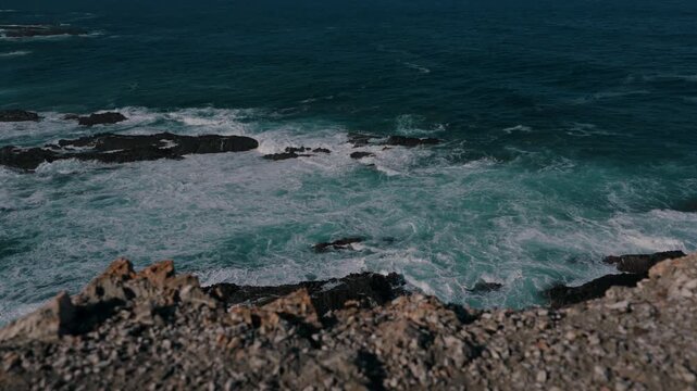 Waves rolling over rocky reefs seen from the cliff edge, Cabo Sardao, Portugal