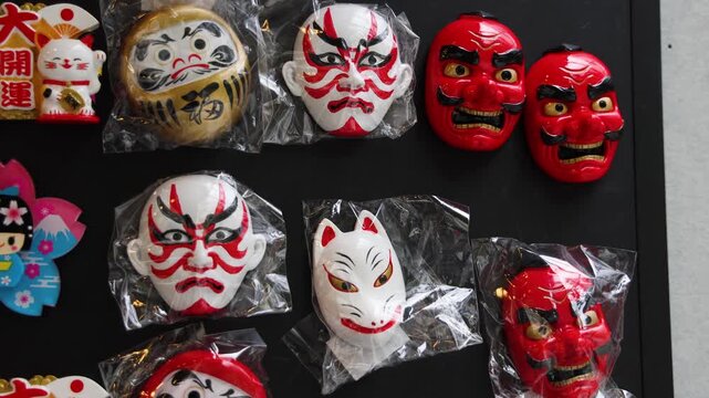 Japanese tourist souvenirs and gifts with symbols of Japan, daruma figure, kitsune fox, tengu mask, mount Fuji, fridge magnets, maneki-neko figurine, key ring keychain, local gift shop in Tokyo, Japan