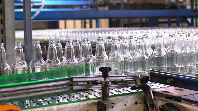 Glass factory, production of glass containers. Packaging of food containers. Robotics in industry. Modern technologies, robotic machines produce products. Technological work at the plant.