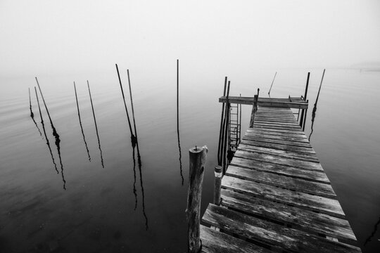 Pier antigo em preto em branco em um lago calmo