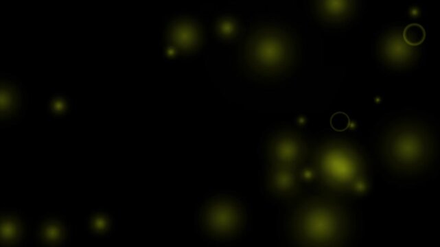 Golden bokeh particles floating gently across dark background creating peaceful atmospheric video motion clip graphic effect