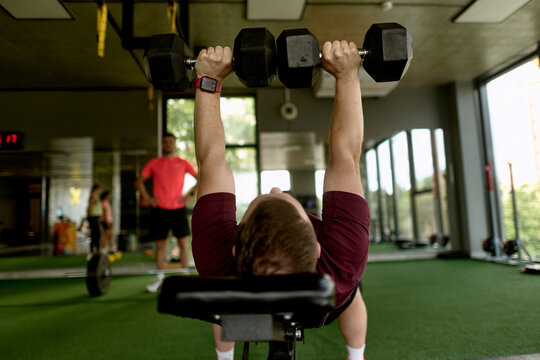 Man Performing Dumbbell Bench Press at Gym