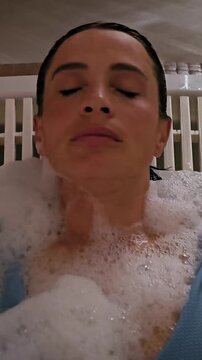 Relaxation in a bubble bath with soft lighting in a quiet indoor setting
