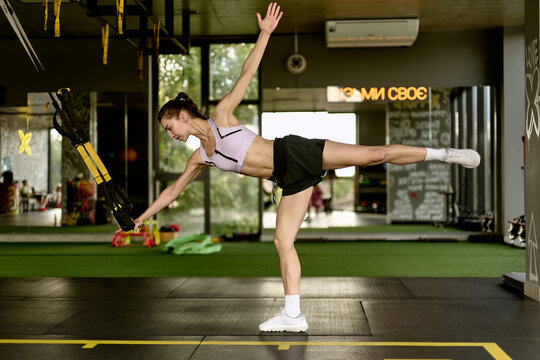 Woman Performing Single Leg Balance Exercise with TRX