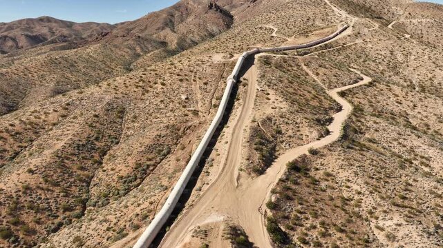 Aerial shot of the Los Angeles Aqueduct as it passes over some low mountains in California. The aqueduct supplies water to Los Angeles and Southern California.